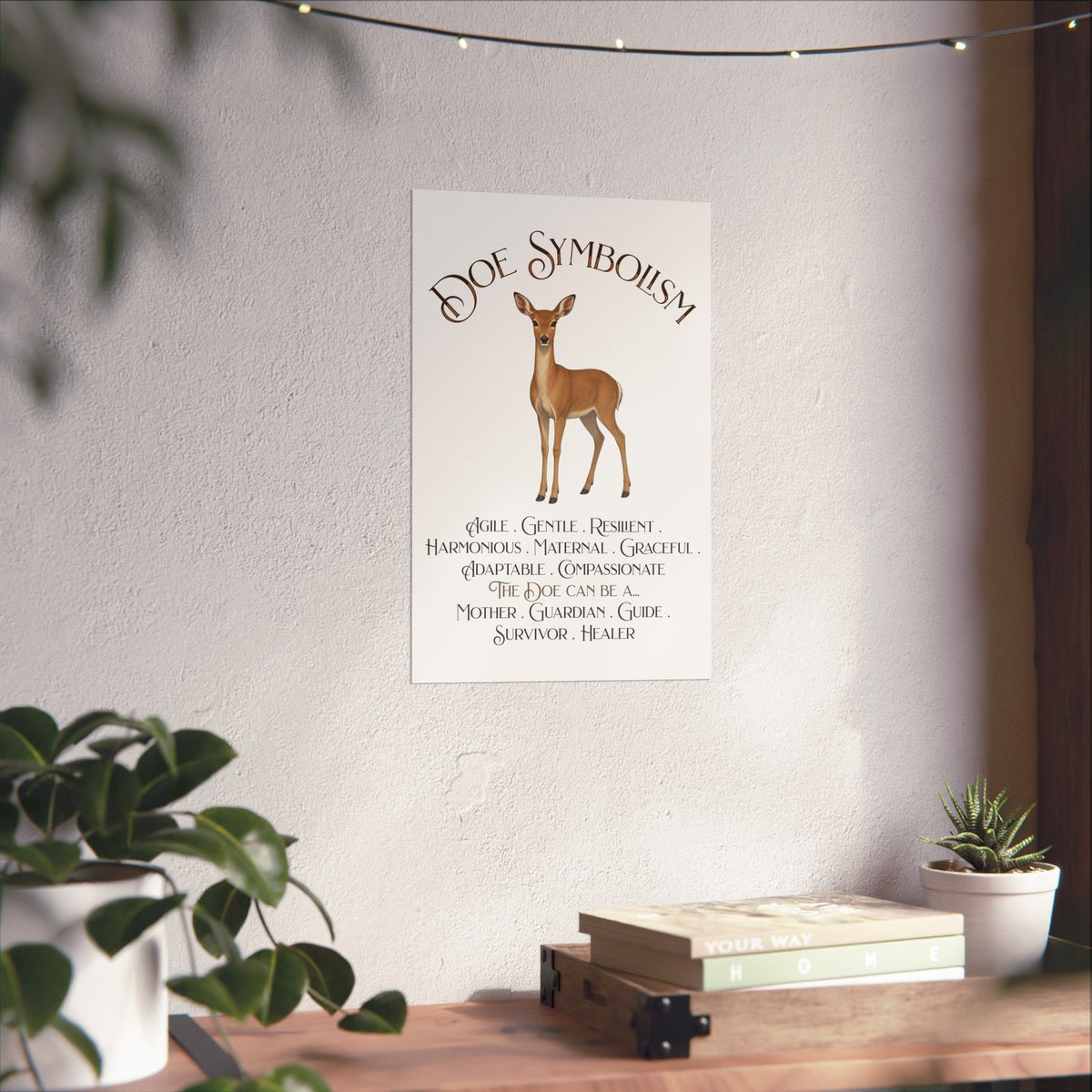 A vertical wall art print featuring the text 'DOE SYMBOLISM' above an illustration of a deer and a list of qualities for the doe, displayed on a textured wall in a styled interior setting with plants and a wooden shelf.