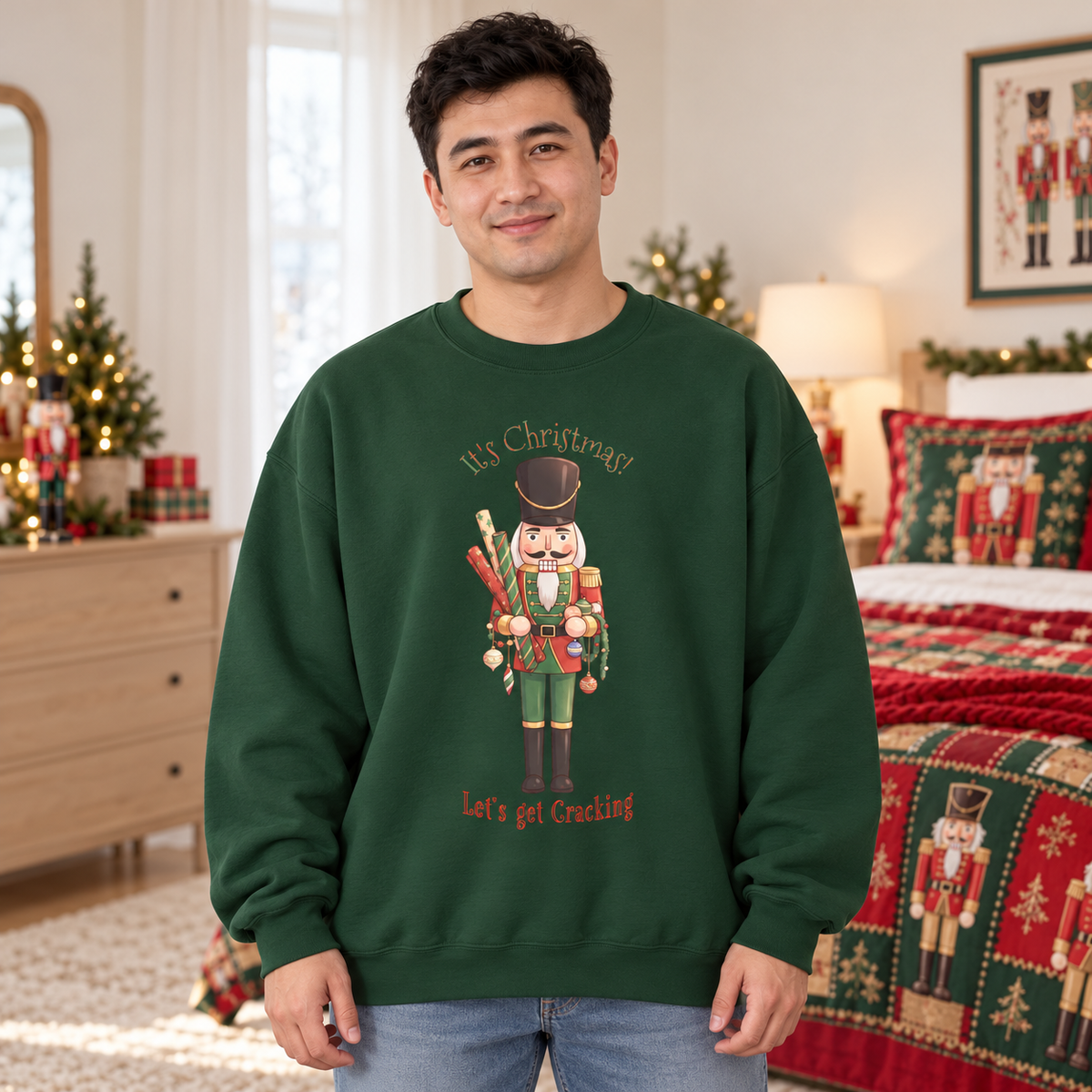 A man wearing a dark green crewneck sweatshirt with a nutcracker holding wrapping paper and decorations surrounded by the text 'It's Christmas! Let's get Cracking' in a decorated holiday bedroom setting.