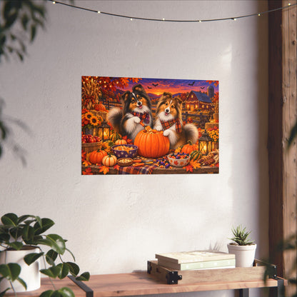 A rectangular wall art print showing two shelties carving a jack o' lantern, displayed on a white wall above a wooden surface with books and small plants.