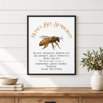 A framed art print featuring a honey bee illustration and the text 'Honey Bee Symbolism' with symbolic text, displayed on a white shiplap wall above a wooden console table with a vase of flowers, a bowl, and books.