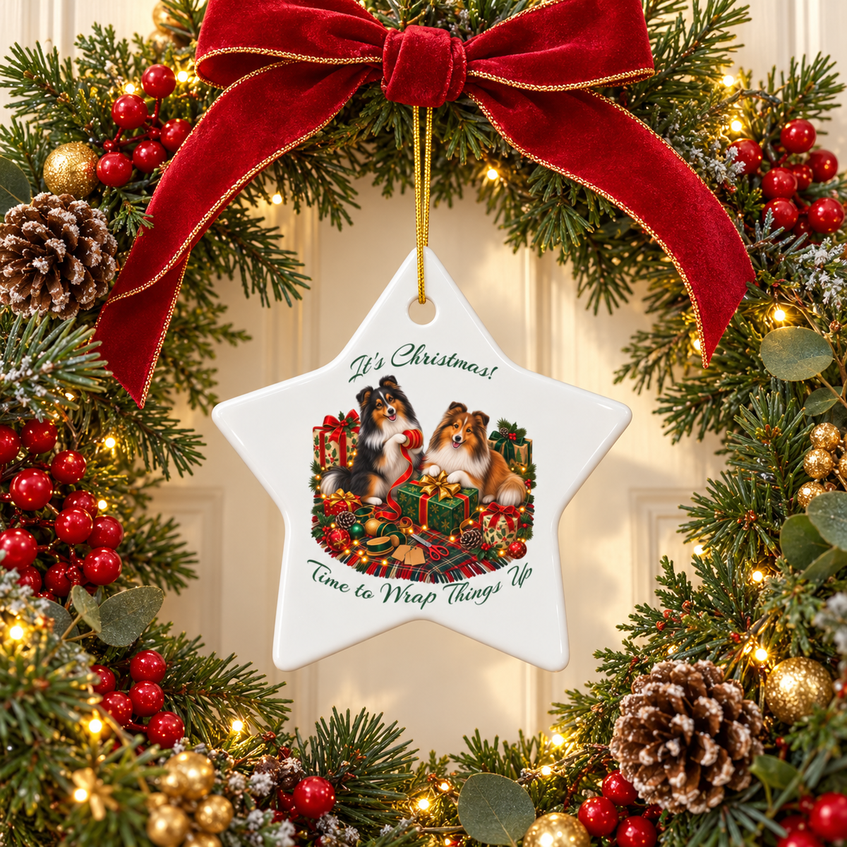 A white star-shaped Christmas ornament with a printed illustration of two shelties and the text 'It's Christmas! Time to Wrap Things Up,' hanging from a red velvet bow on a decorated Christmas wreath with lights and pinecones.