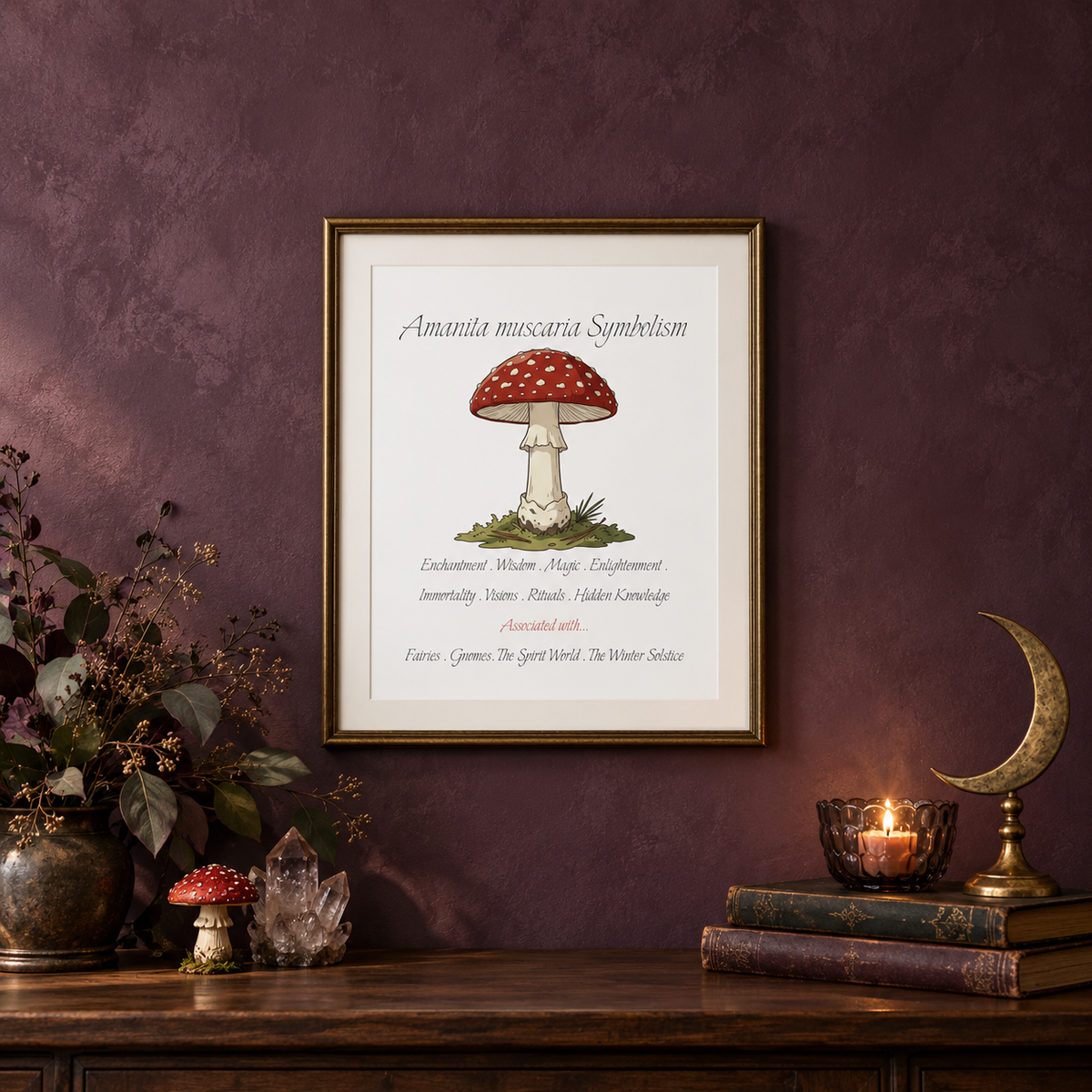 A framed art print featuring a red and white spotted mushroom with the text 'Amanita muscaria Symbolism' and additional mystical words, displayed on a textured dark purple wall above a wooden console table with a vase of branches, a mushroom figurine, a crystal, books, a candle, and a moon decoration.